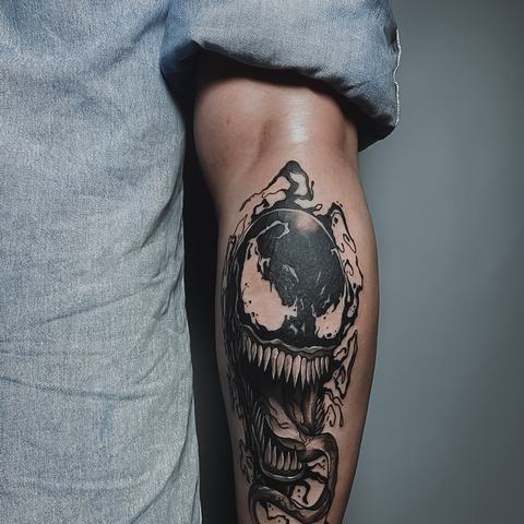 A dark Venom design flows along the lower leg, combining fluid black shapes, a wide grin and sharp teeth into an intense composition