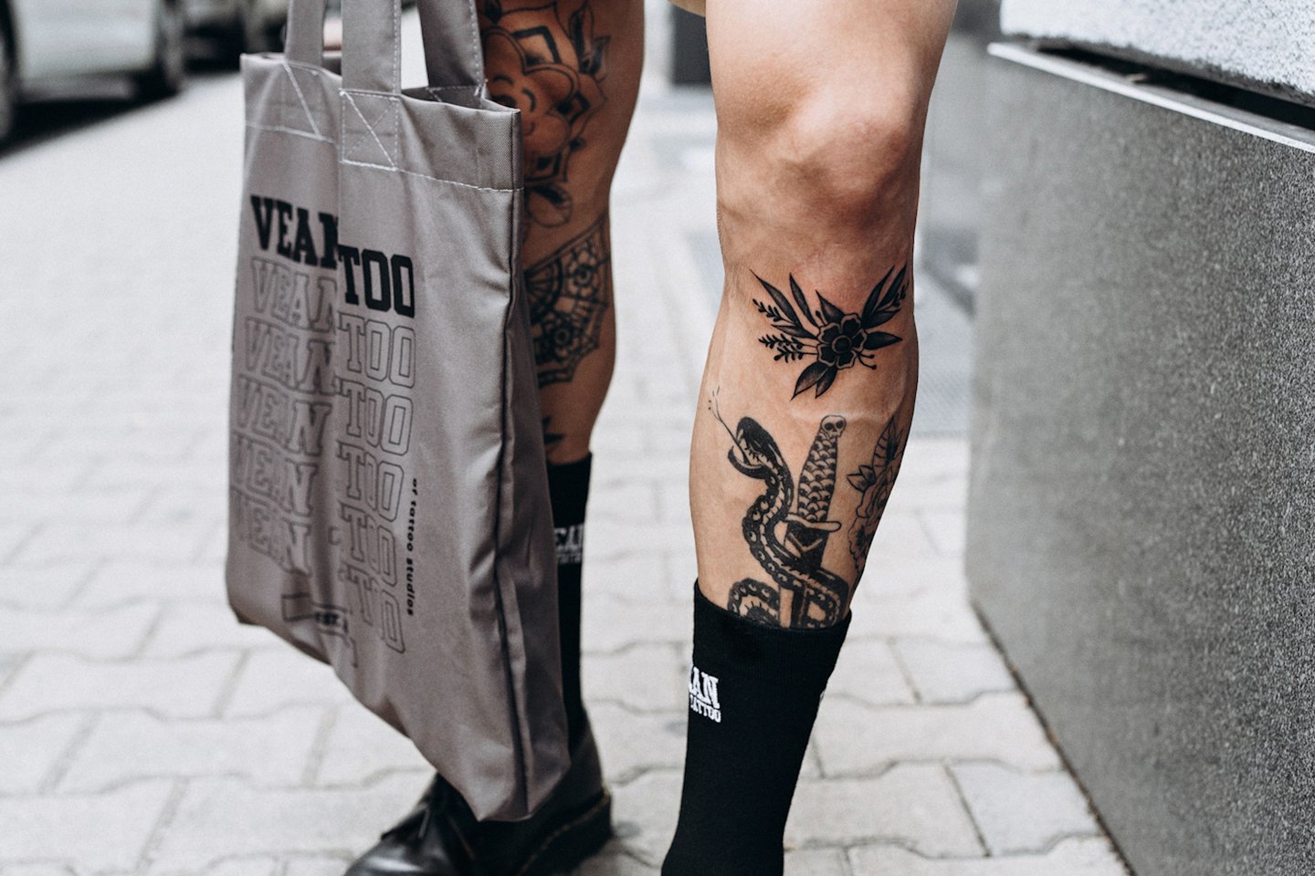 Lähivaade jalatatoveeringutele: mustvalge madu ja lillemotiivid säärel ja reiel