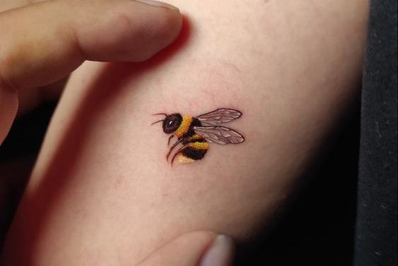 Tiny realistic bee tattoo with delicate translucent wings