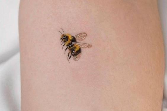 Small realistic bumblebee tattoo with a fuzzy yellow and black body
