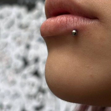 Labret-huuleaugustus väikese titaanist kuuliga VEAN Tattoo stiilis Tallinnas