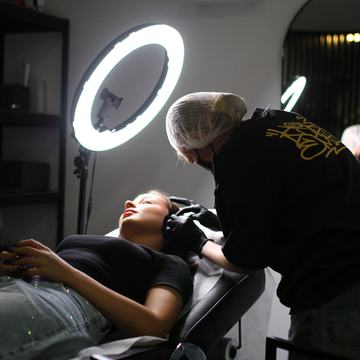 Piercer teeb kliendile stuudios piercingut