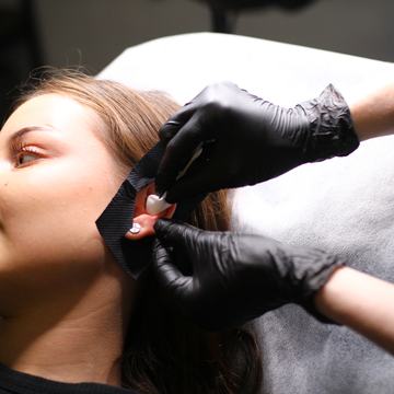 Piercer teeb kliendile huulepiercingut